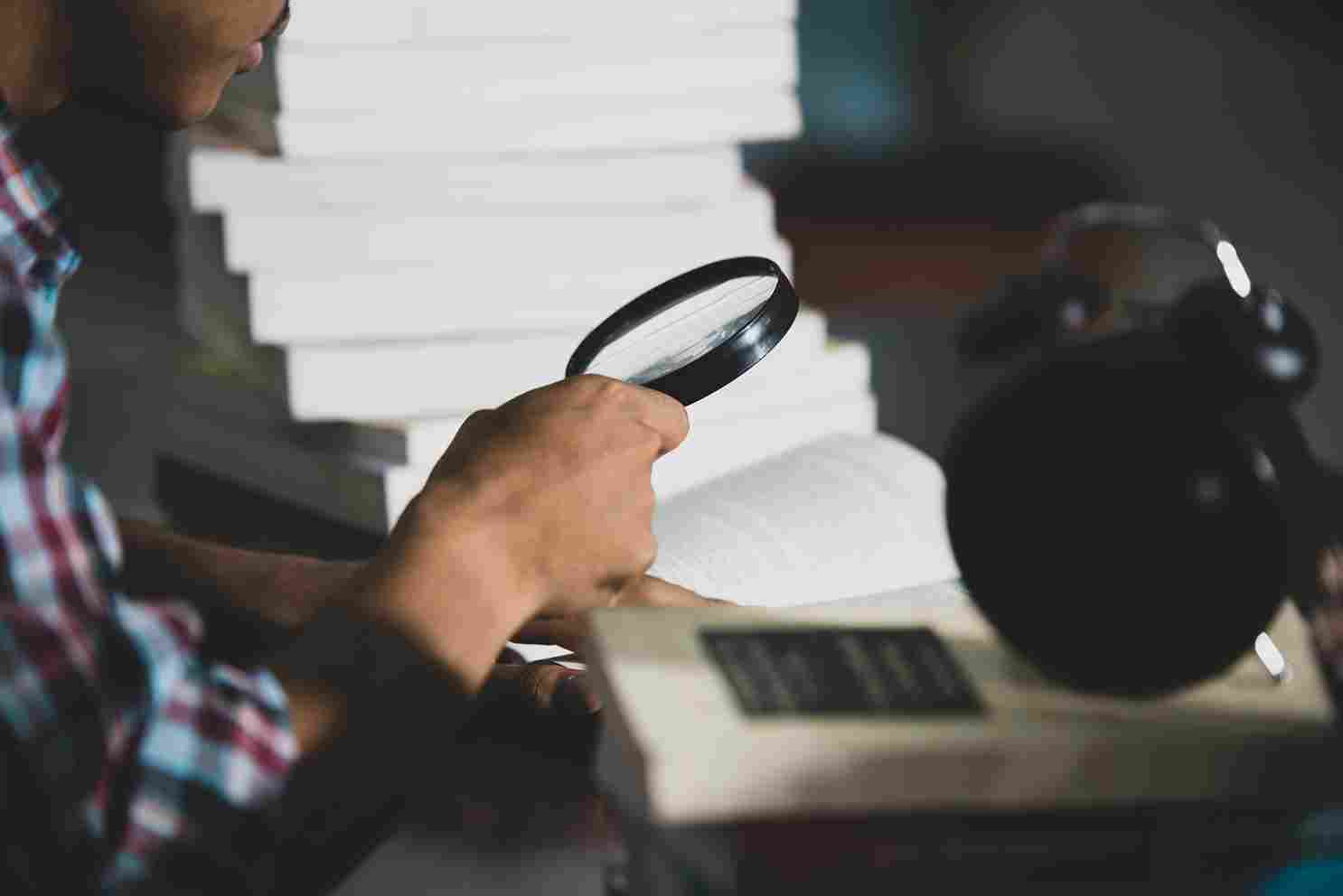 educational-theme-close-up-student-looking-through-magnifying-glass-book_11zon